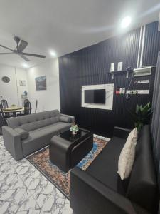 a living room with two couches and a tv at Homestay Una Kangar in Kangar