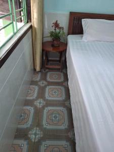 a room with two beds and a table next to a window at Tam hien ho in Tân Hiệp +2 photos