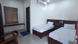 a hotel room with two beds and a window at Masterkey stay in Kakkanad