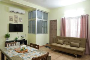 a living room with a table and a couch at Villa LOR in Pondicherry