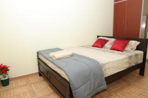 a bedroom with a bed with two red pillows on it at Villa LOR in Pondicherry