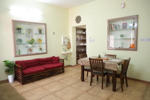 a living room with a red couch and a table at Villa LOR in Pondicherry