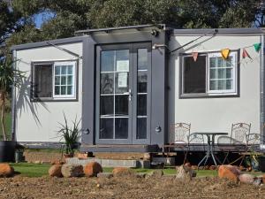 a tiny house with a porch and a table at The Country Nook in Manildra