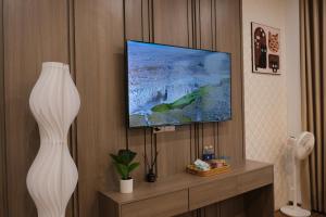 a living room with a tv and a vase at AnChi Homestay in Hòa Bình