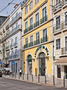 a yellow building with a sign on it on a street at Lisbon Five Stars Apartments Bica in Lisbon