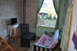 a living room with a wood stove and a couch at Santa Irene in Lago Meliquina