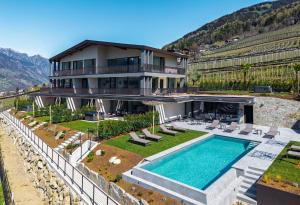 a house with a swimming pool and a villa at Residence Gloria Dei in Schenna