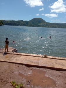 a boy standing on a dock in a body of water at Saumualevu in Kavala +9 photos