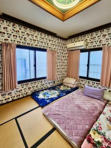 a room with a large bed in a room with windows at 明月民宿 in Takatsuki