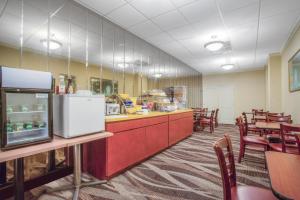 a restaurant with a counter and tables and chairs at Days Inn by Wyndham Liberty in Ferndale