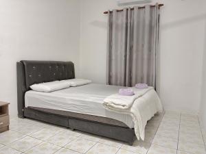 a bed with white sheets and pink pillows on it at Rumah Impian Bapa in Semporna