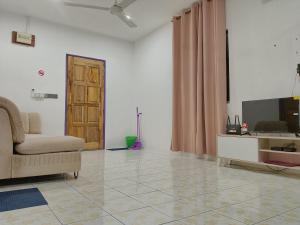 a living room with a couch and a television at Rumah Impian Bapa in Semporna