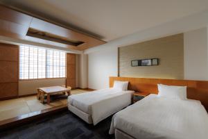 a hotel room with two beds and a table at Nara Plaza Hotel in Tenri +134 photos