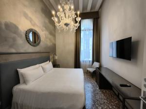 a bedroom with a large white bed and a chandelier at Ca' Del Campo in Venice