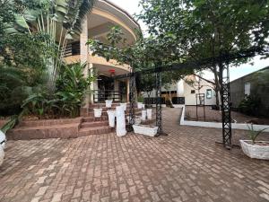 a brick courtyard with a gate and a building at Studio with Sauna & Massage in Kampala