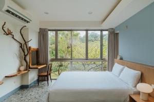 a bedroom with a bed and a large window at Toptai Kenting BY REINDEER in Kenting