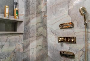 a shower in a bathroom with a marble wall at SVS Bhawan in Ulhāsnagar