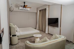 a hotel room with a couch and a bed at SVS Bhawan in Ulhāsnagar