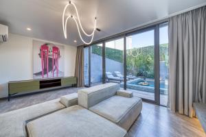 a living room with a couch and a chandelier at XO Canggu adults only in Canggu