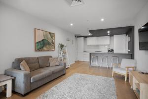 a living room with a couch and a kitchen at Rooftop infinity pool - St Kilda luxury in Melbourne