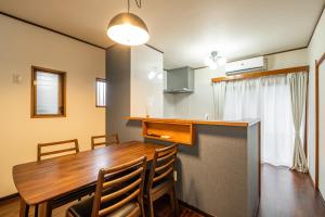 a kitchen and dining room with a wooden table and chairs at Dream Bridge Fuji House in Fuji
