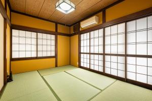 an empty room with yellow walls and windows at Dream Bridge Fuji House in Fuji +26 photos