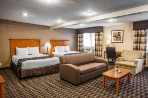 a hotel room with two beds and a couch at Clarion Inn Renton-Seattle in Renton