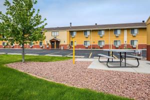 a picnic table and a tree in front of a building at Quality Inn Janesville North in Janesville