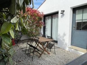a picnic table and chairs in front of a house at La Cabane Manon in La Guérinière