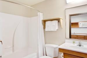a bathroom with a shower and a toilet and a sink at WoodSpring Suites Columbus NE I-270 Airport in Gahanna +25 photos