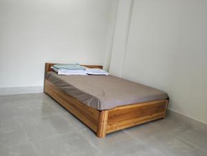 a wooden bed in a corner of a room at Windfall Homestay in Dimapur