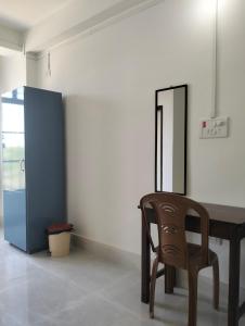 a wooden table and a chair in a room at Windfall Homestay in Dimapur