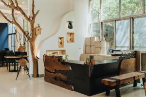 a room with a table and a tree and a bench at Toptai Kenting BY REINDEER in Kenting
