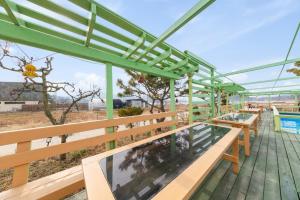 a deck with benches and a view of the beach at Abientot Spa Pension Ganghwa in Incheon