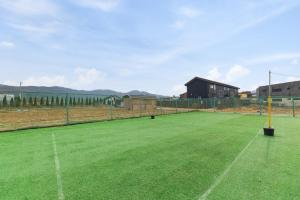 a tennis court in a field with a fence at Abientot Spa Pension Ganghwa in Incheon +9 photos