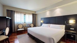 a hotel room with a large white bed and chairs at Attica21 Coruña in A Coruña +70 photos