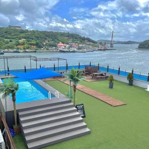 a swimming pool with palm trees next to a body of water at Yeosu Sun Beach Pension in Yeosu