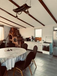 a kitchen with a table and chairs in a room at Casa Rariana in Călimăneşti