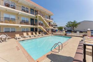 a large swimming pool in front of a hotel at Surfside Getaway with Heated Pool & BBQ Grill in North Wildwood