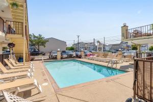 a swimming pool with chaise lounge chairs and a swimming pool at Surfside Getaway with Heated Pool & BBQ Grill in North Wildwood