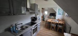 a kitchen with a sink and a table with chairs at Ferienwohnung bei Natie in Brilon +17 photos