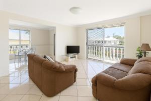 a living room with two couches and a television at Redcliffe Villa in Redcliffe