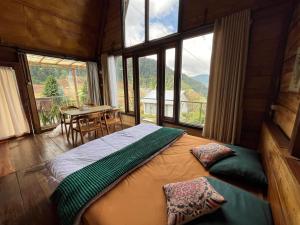 a bedroom with a bed in a room with a table at Satha private villa Dieng in Banjarnegara