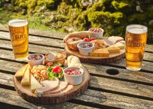 two plates of food and two glasses of beer on a wooden table at The Station Inn - Ribblehead in Ribblehead Station