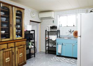 a kitchen with a blue sink and a refrigerator at マホロバハウス ペットも泊まれる1棟貸 in Tadotsu