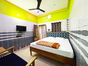 a bedroom with a bed and a flat screen tv at HOLIDAY INN in Konārka
