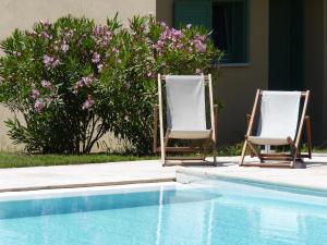 two lawn chairs sitting next to a swimming pool at Residence Les Sellettes in Saint-Tropez