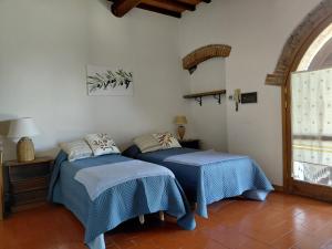 two beds sitting next to each other in a room at Il Peppolo Country House in Pelago