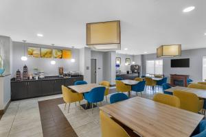 a cafeteria with tables and chairs and a kitchen at Comfort Suites West Jacksonville in Jacksonville