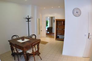 a dining room with a table and a clock on the wall at Apartmán Old centre - Rybárska brána in Bratislava